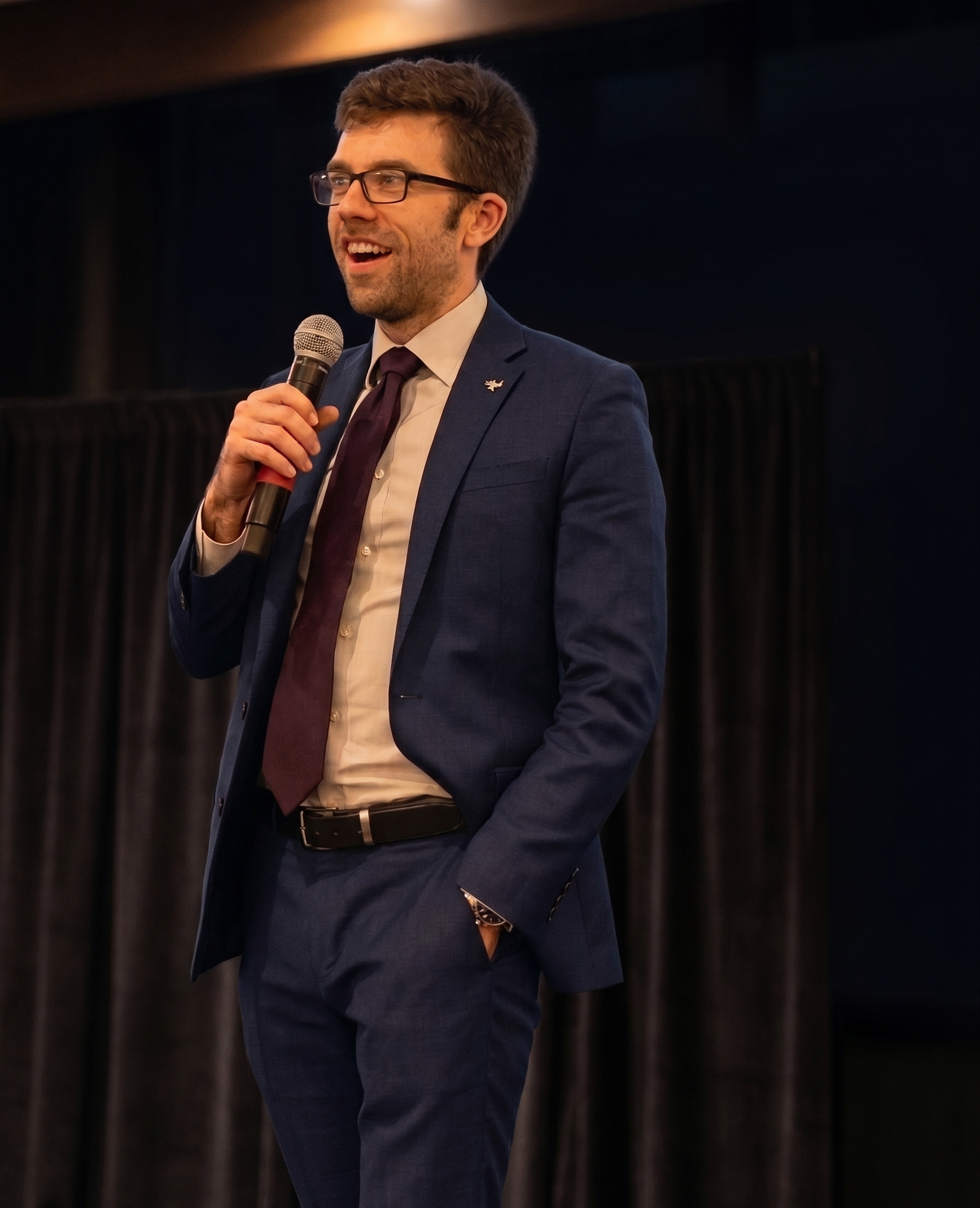 Christian Moriarty speaking at a microphone